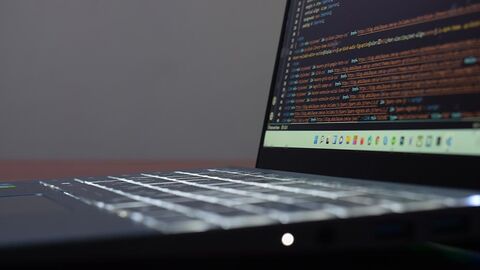 Laptop, auf dem Programmcode zu sehen ist.